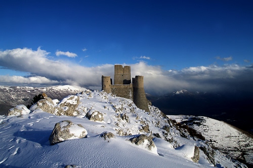 Immagine con neve, nuvole, castello, cielo, torri, montagna, rocca, inverno, pietre, rocce