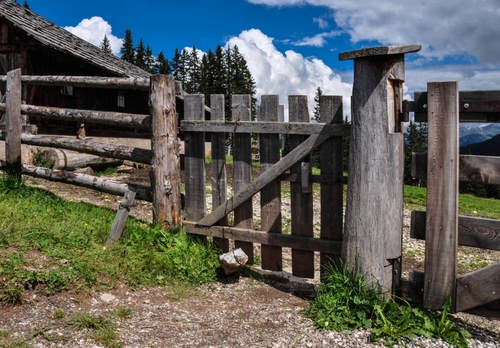 Immagine con legno, cancello, nuvole, staccionata, alberi, baita, recinto, cielo, erba