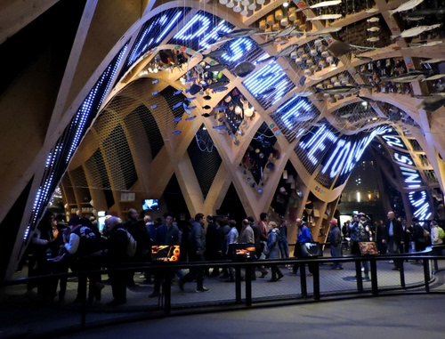 Immagine con expo, persone, padiglione, gente, legno, scritta, struttura, scritte, luci, passanti