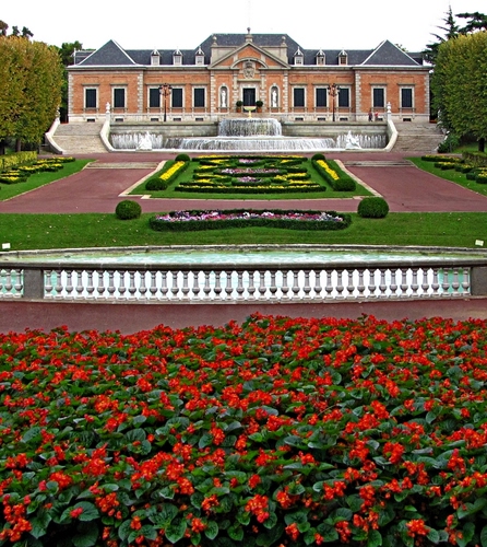 Immagine con fiori, aiuole, giardino, villa, rosso, palazzo, balaustra, erba, castello, verde, finestre, fontana